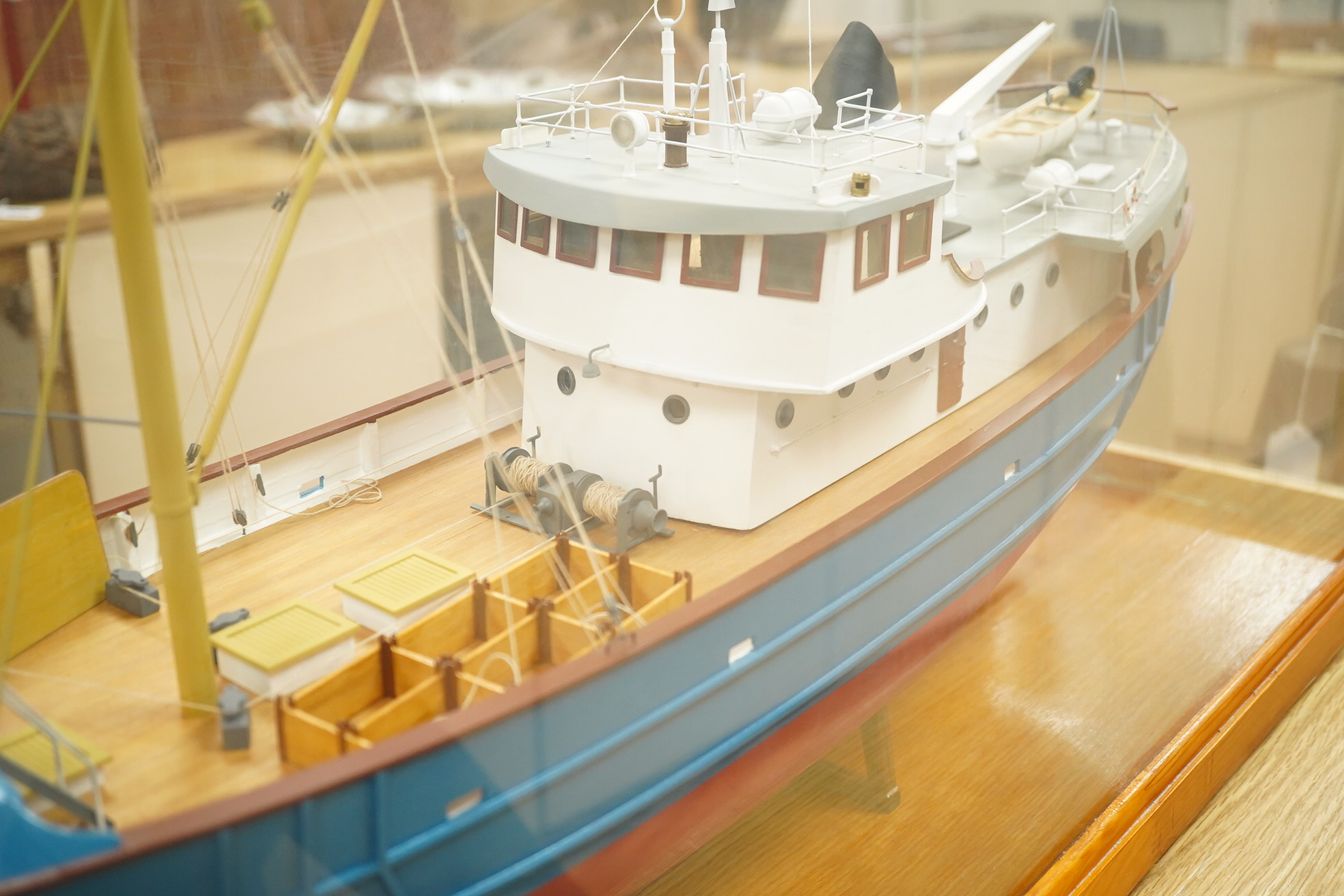 A model of a fishing trawler ship constructed from a kit by Billings Boats models, of painted wood construction, finished to a high standard with a good level of detail, presented in a glazed cabinet on a wooden base, ca